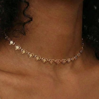 Gold heart-shaped necklace on a person's neck